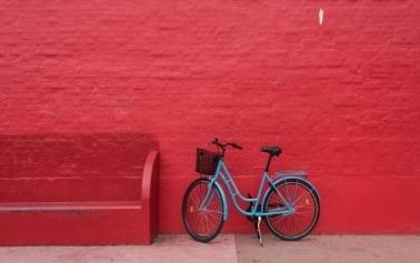 Blue bicycle against red wall