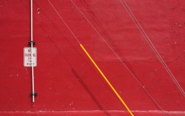 Red wall with no parking sign and wires