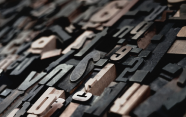 Different English alphabets made out of cardboard scattered around