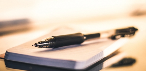 a pen on a notepad in a dull background
