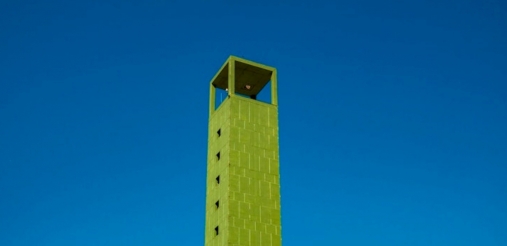 Image of a tall green building with a blur background