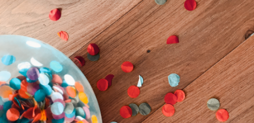 illustration image showing an assorted color of sprinkle paper dots on brown wooden floor