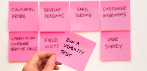 Person holding a pink sticky note