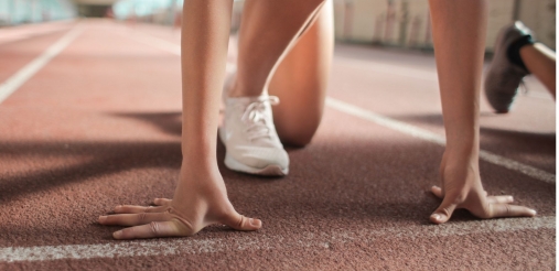 person kneeling to get ready at the start line of a race