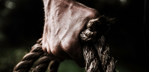 a fist clinching on a roll of ropes