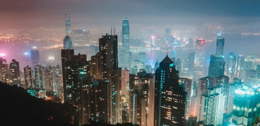 A lot of tall building can be seen lit at the night time.
