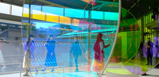 An image displaying people inside a building filled with big glasses
