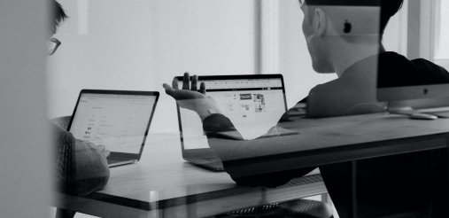 Two persons are seen working on their laptops.