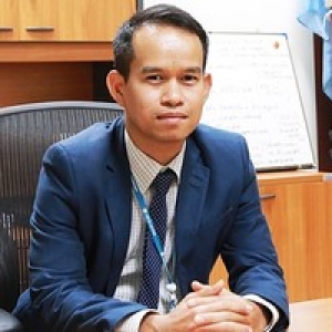 Tob posing in a professional attire at his desk