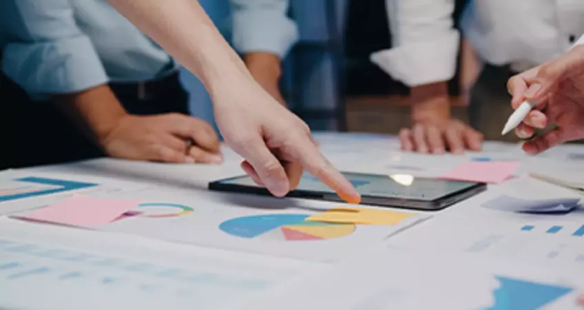 a man's hand pointing towards a page with diagram drawn on it
